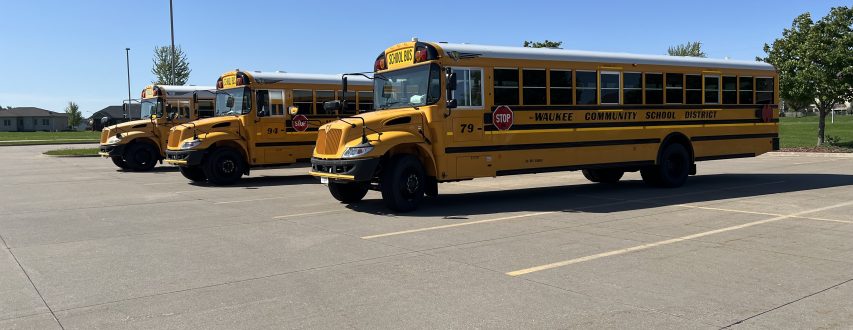 Three buses in a parking lot at a Waukee CSD school.