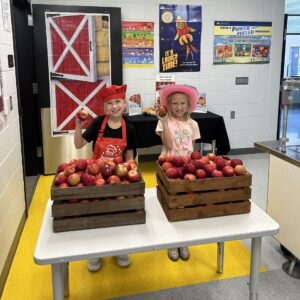 Two Sugar Creek Elementary student serving apples.