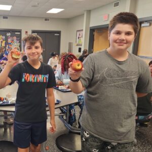 Two Waukee Elementary students holding apples.