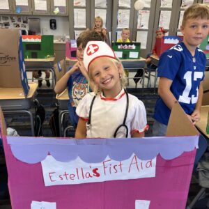 Student in her first aid shop that she created out of cardboard for a school social studies project.