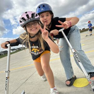 Two girls on scooters for physical education class