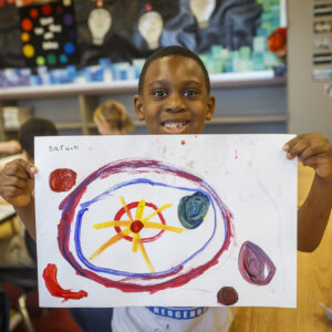 Student holding up his artwork. 