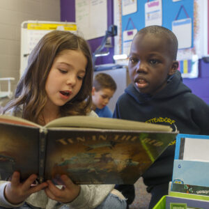 Two students reading a book.