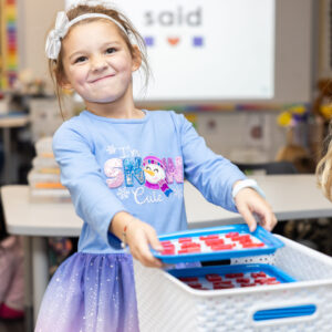 Kindergarten student with letter board.