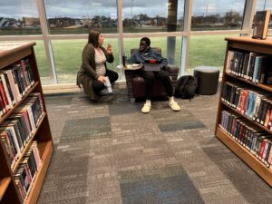 Teacher helping a student in a school library.