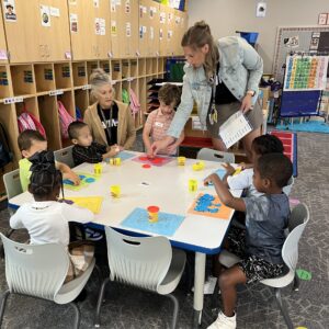 Teacher with students at a table.