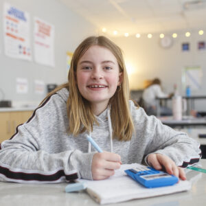 Student smiling at the camera in class