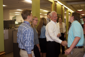 John Schreurs, CEO, shakes hands with Waukee APEX student associates. 